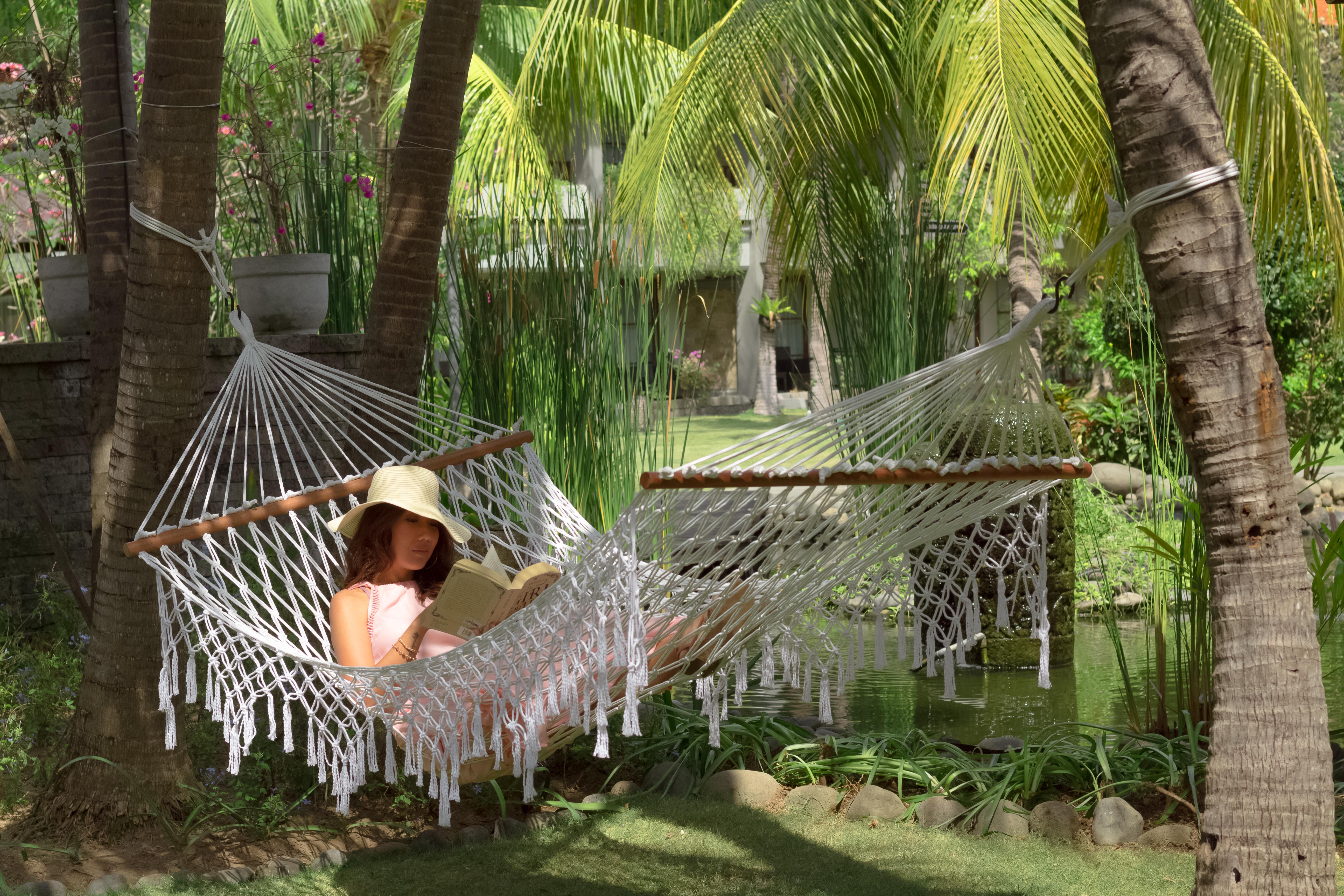 Bali Dynasty Resort กูตา ภายนอก รูปภาพ A woman relaxing in a hammock